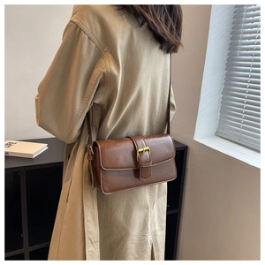 Detail shot of the vintage brown wax leather crossbody bag with a golden square buckle