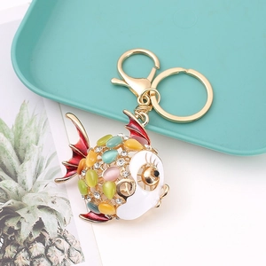 Close-up of colorful crystal fish keychain with gold finish and vibrant gemstones