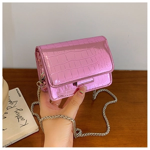 Detail of pink croc-embossed square bag with metallic finish and silver chain strap
