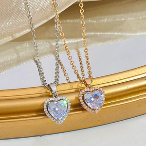 Colliers élégants en forme de cœur or et argent avec zircons sur fond de soie