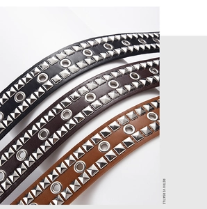 Detail of retro punk belts with square rivets and metal eyelets in three colors