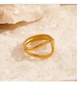 Detailed macro view of 18K gold plated wave ring displayed on white crystal stone