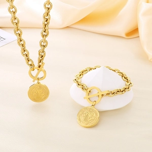 Close-up of gold chunky chain necklace set with OT buckle and St. Benedict medal