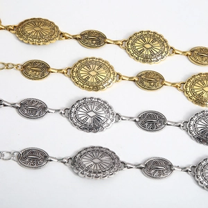 Chic gold and silver metal waist chains with vintage oval engraved buckles on white background