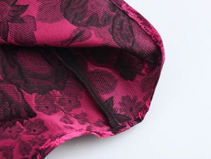 Macro shot of rose red and black floral jacquard fabric with detailed stitching