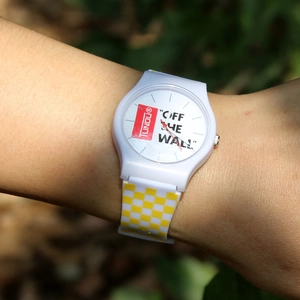 White casual quartz watch featuring a yellow checkerboard pattern strap on a model's wrist