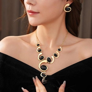 Vintage geometric oval jewelry set with golden necklace and black stone earrings on model