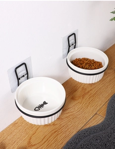 Dual wall-mounted ceramic cat bowls with black metal holders and fish bone pattern details