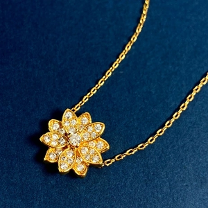 Exquisite 18K gold plated lotus flower necklace with pavé zircons on a dark background