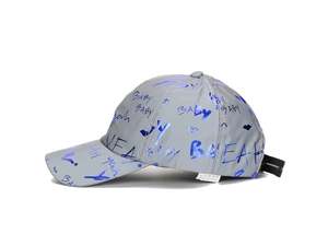 Detail of reflective fabric baseball cap with metallic blue lettering and graphics