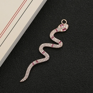 Macro shot of rose gold snake pendant with micro-paved white and red cubic zirconia