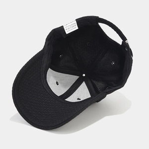 Inside view of black waffle baseball cap showing 100% polyester lining and metal buckle