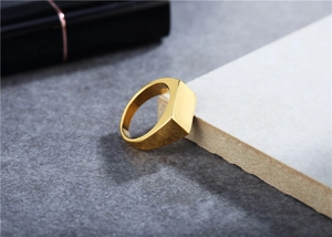 Macro detail of polished gold-plated rectangular signet ring with smooth mirror finish