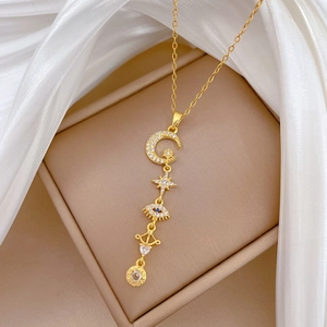 Detail view of gold tassel necklace with star, moon, evil eye, and LOVE engraved pendant