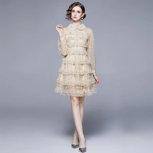 Robe élégante en dentelle crème à volants avec col Peter Pan portée par un mannequin