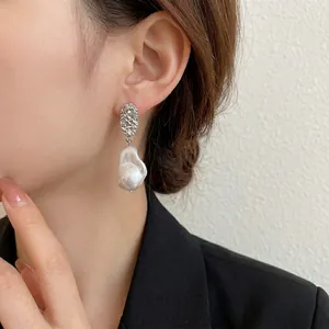 Baroque irregular pearl drop earrings with textured silver metal for a vintage look