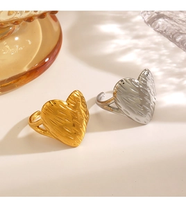 Close-up of gold and silver heart rings with hammered texture on warm background