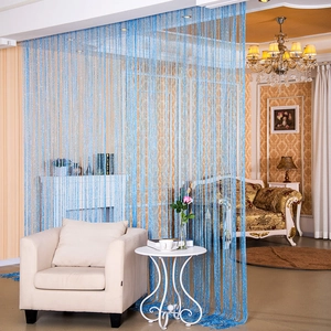 Tenda a fili blu glitterati usata come divisorio decorativo in un soggiorno moderno