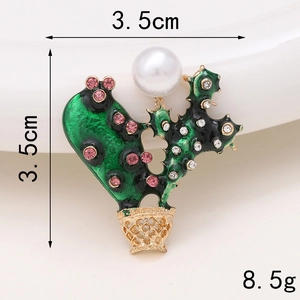 Macro shot of green enamel cactus charm with pink rhinestones and white pearl detail