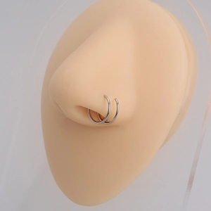 Detail view of a silver double-layered nose ring with sparkling diamonds on a model