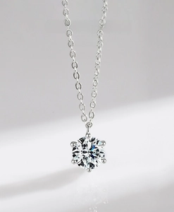 Macro shot of 925 sterling silver necklace with brilliant six-prong diamond pendant