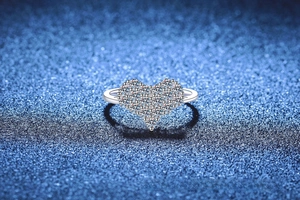 Macro view of heart-shaped S925 sterling silver ring with pavé moissanite cluster setting