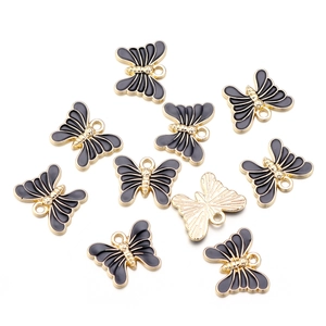 Macro view of ten black and gold enamel butterfly charms for DIY jewelry making
