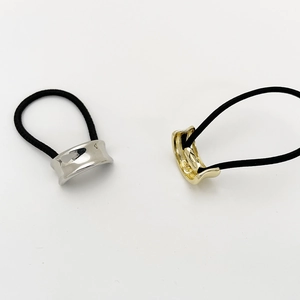 Elastic hair ties with gold and silver U-shaped metal accents on a white background