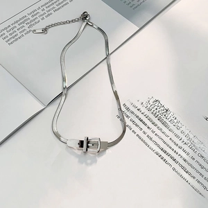 Close-up of silver snake chain necklace featuring a unique metal belt buckle pendant