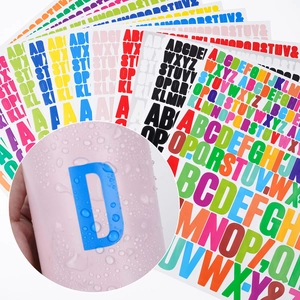 Close-up of waterproof colorful letter stickers with droplets on a blue surface