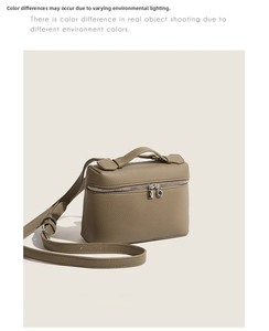 Macro detail of khaki litchi grain leather bag with silver hardware and lock charm