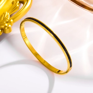 Macro shot of 18k gold plated stainless steel bangle with inlaid black square gemstones