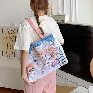 Détail du cabas en toile montrant la bandoulière rose et l'illustration de ville d'hiver