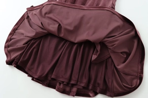 Close-up of dark burgundy velvet dress with smooth lining and pleated interior layers
