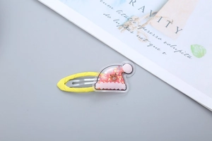 Detail of a yellow hair clip with a transparent Christmas hat and gold star sequins