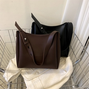 Close-up of minimalist large tote bags in coffee and black with adjustable wide straps