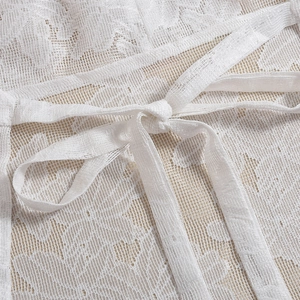 Detailed macro view of white floral lace fabric texture and adjustable tie-up ribbons