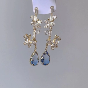 Elegant gold butterfly tassel earrings with blue waterdrop zircon on a display card