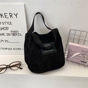 Détail du sac cabas en velours côtelé noir avec étiquette attitude et accessoires