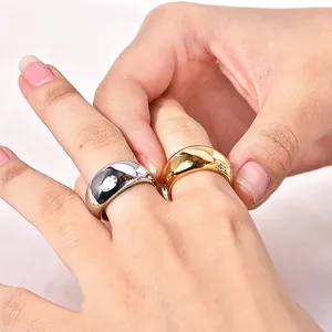 Polished gold and silver wide surface rings shown on hand in minimalist retro style