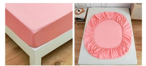 Close-up of pink fitted sheet with elastic edges on a mattress in a modern bedroom