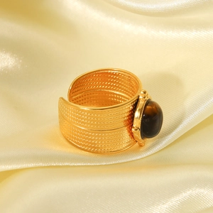Macro detail of vintage textured 18K gold stainless steel ring with oval tiger eye stone