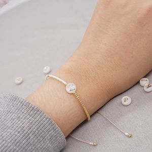 Bracciale minimalista con ciondolo a lettera W dorata e cinturino intrecciato regolabile