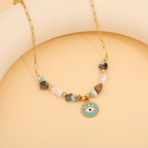 Detail of gold beaded necklace featuring blue evil eye pendant with natural stones and pearls