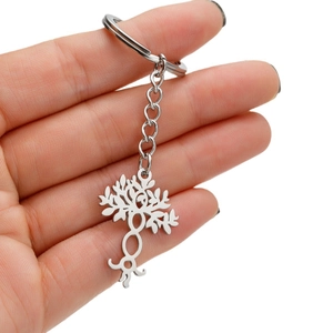 Silver stainless steel tree of life keychain pendant held in hand for size visualization