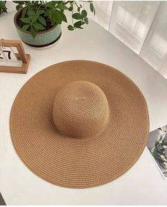 Vue de dessus d'un chapeau de soleil en paille à large bord kaki avec texture tressée d'été