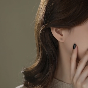 Minimalist S999 sterling silver eight-pointed star stud earrings on female ear model