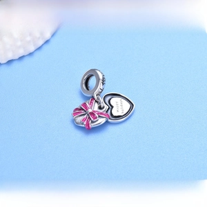 Detailed close-up of 925 sterling silver heart charms with a pink bow and Happy Holidays