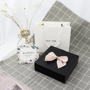 Elegant black jewelry gift box with pink bow and minimalist white carry bag for rose sets