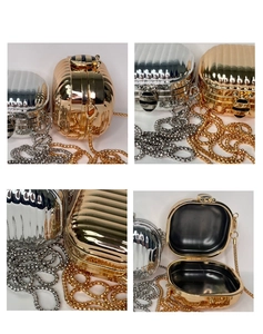 Detail of metallic mini bag with striped texture, bee clasp, and gold chain strap